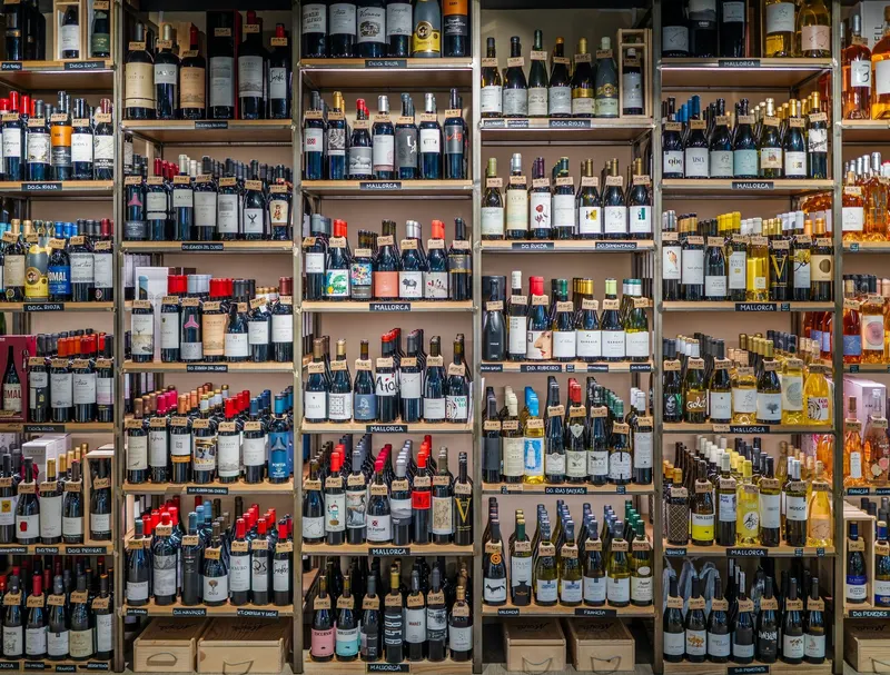 Floor-to-ceiling shelves of wine bottles in a wine shop